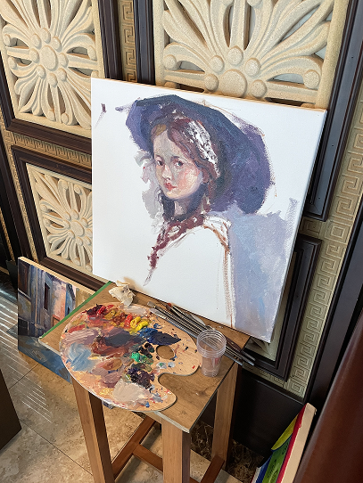 Painting on an easel, palette in hand